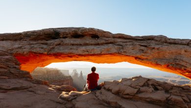 Man enjoying sunrise at Mesa arch, Canyonlands national park, Utah, USA (MR)