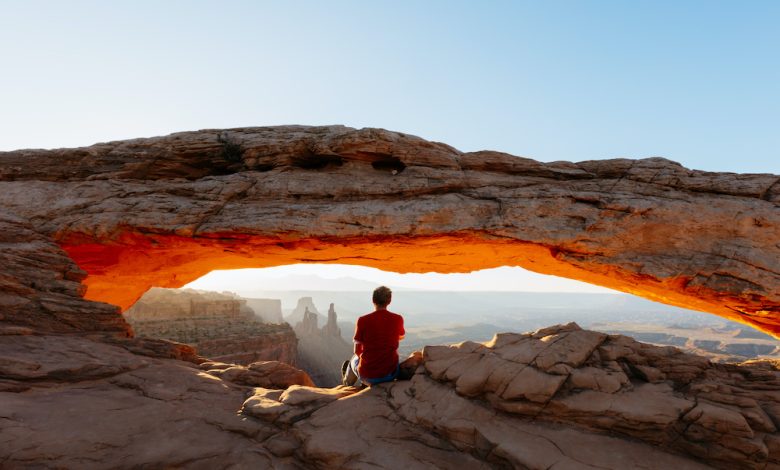 Man enjoying sunrise at Mesa arch, Canyonlands national park, Utah, USA (MR)